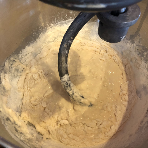 yeast, water, flour and salt mixing together for traditional homemade white bread