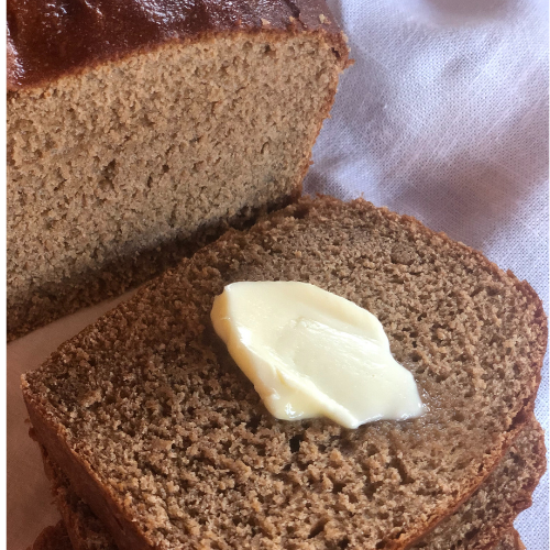fresh baked honey whole wheat bread sliced with a dollop of butter