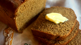 honey whole wheat bread resting on vintage linen napkin