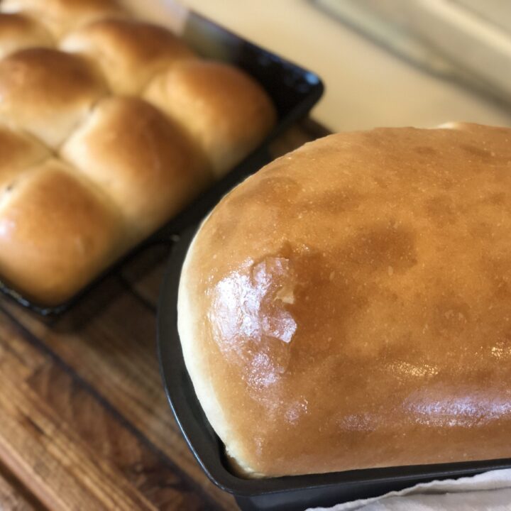 Golden, glossy crust bread loaf and pan of rolls