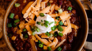 Hearty & healthy pumpkin Chili Topped with sour cream, chives & shredded cheddar