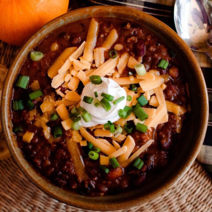 Hearty & healthy pumpkin Chili Topped with sour cream, chives & shredded cheddar
