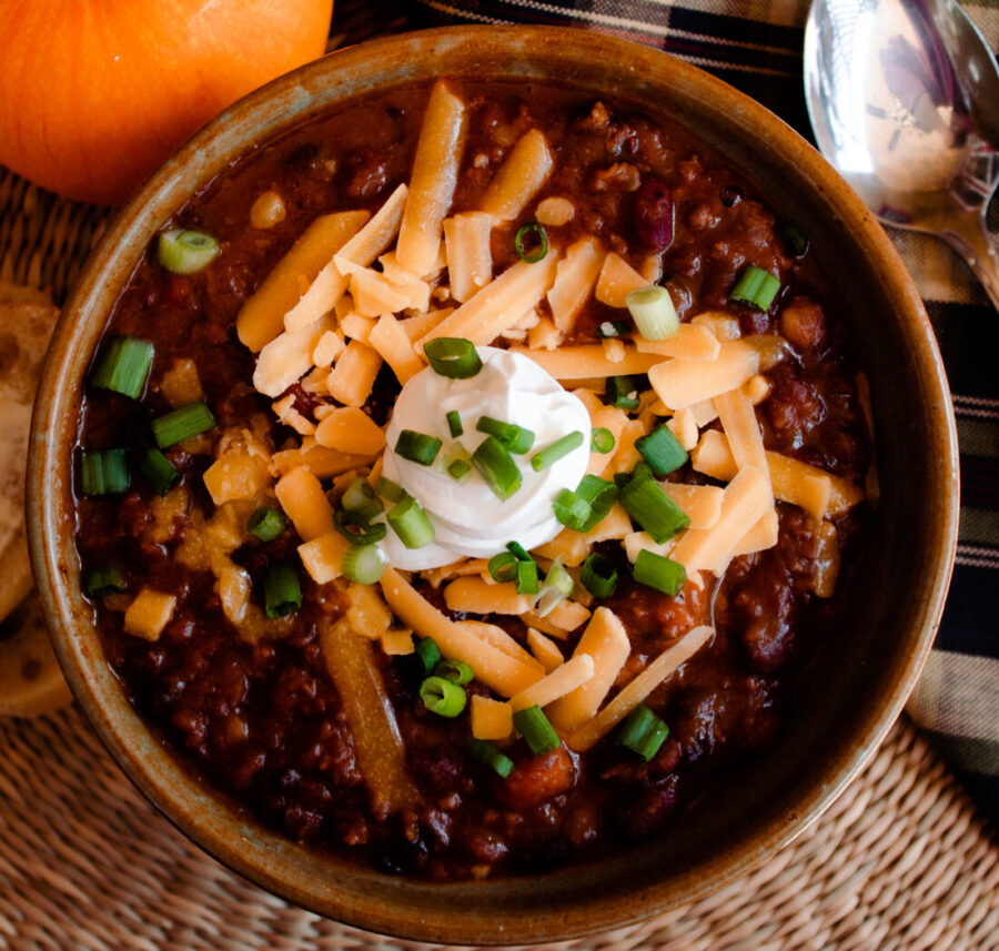 Hearty & healthy pumpkin Chili Topped with sour cream, chives & shredded cheddar