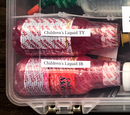 Children's Tylenol and ibuprofen in a diy first aid kit. Dosing tables are printed and stored below